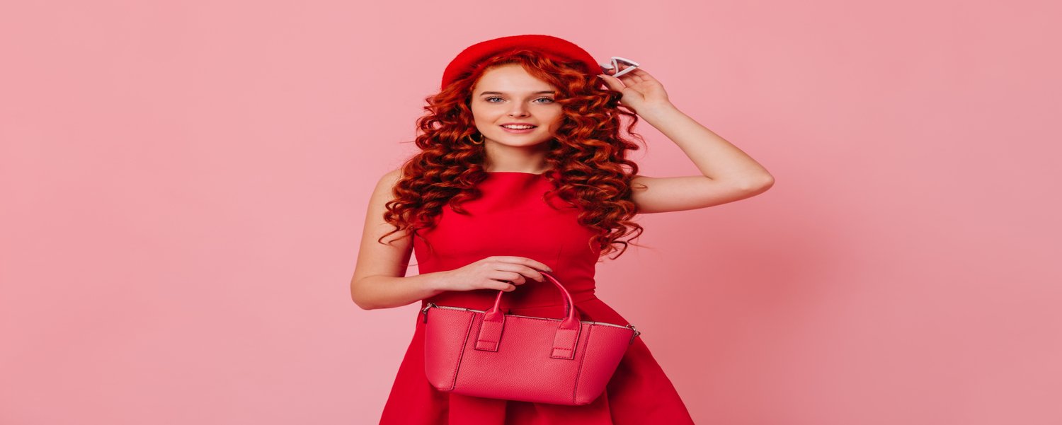 Attractive lady in red hat and bright dress cute smiling, holding leather bag and white glasses